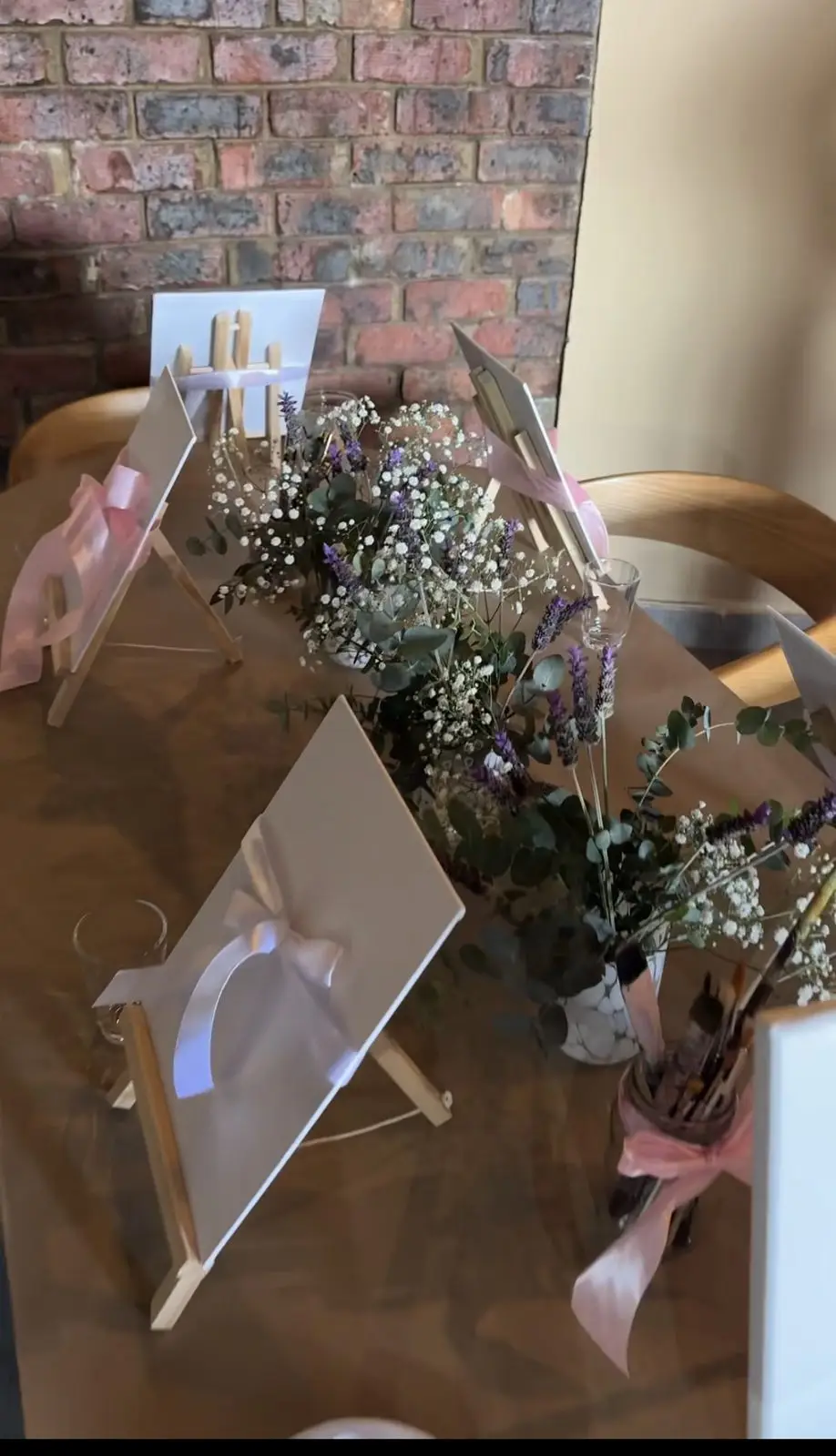 Easels, gypsophila and lavender set out on a table for a creative workshop